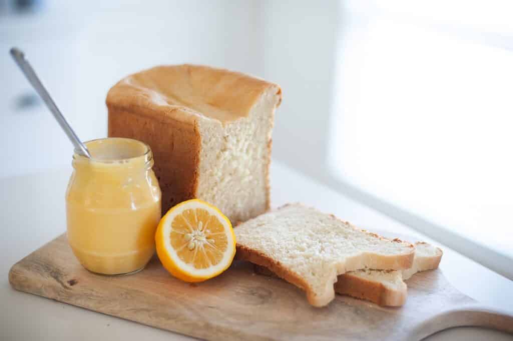 a-loaf-of-bread-on-a-wooden-board-with-lemon-spread