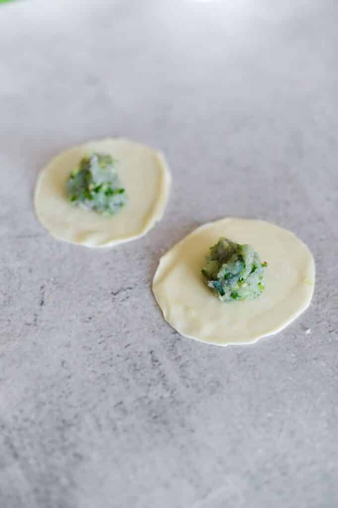 top view of gyoza wrappers with green prawn filling in centre