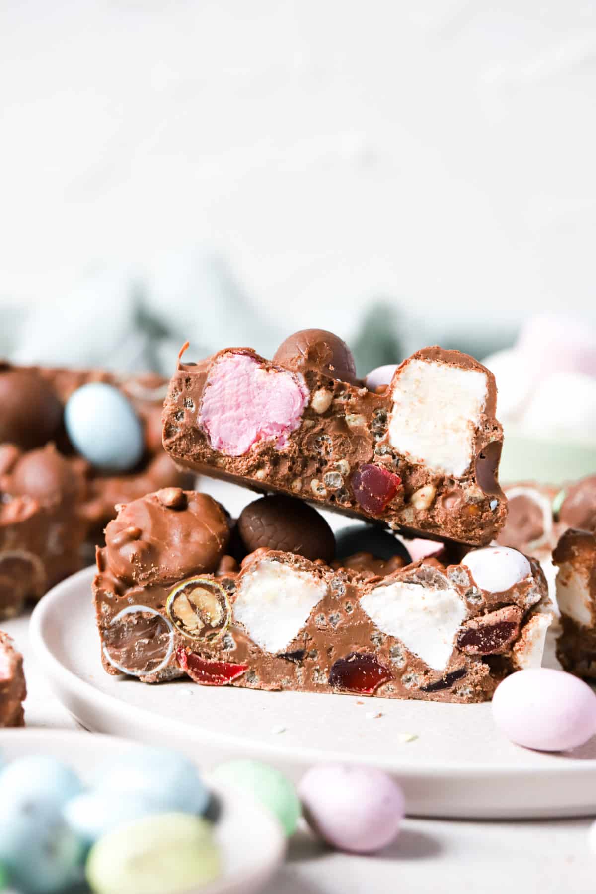 pieces of rocky road arranged on a plate with marshmallows and Easter eggs