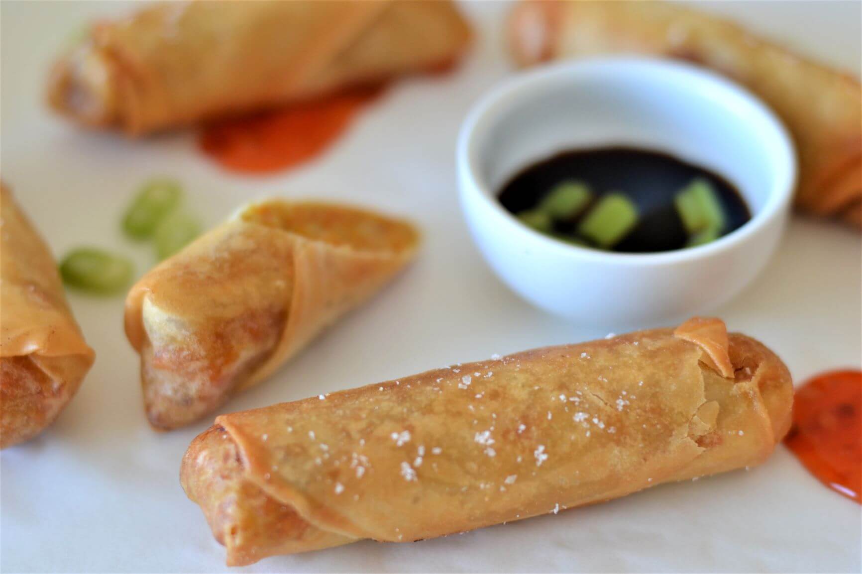 close up of spring rolls on a white board