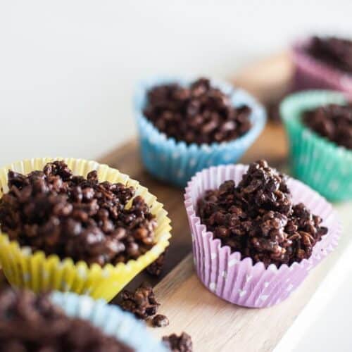 chocolate crackles in coloured cases on wooden tray