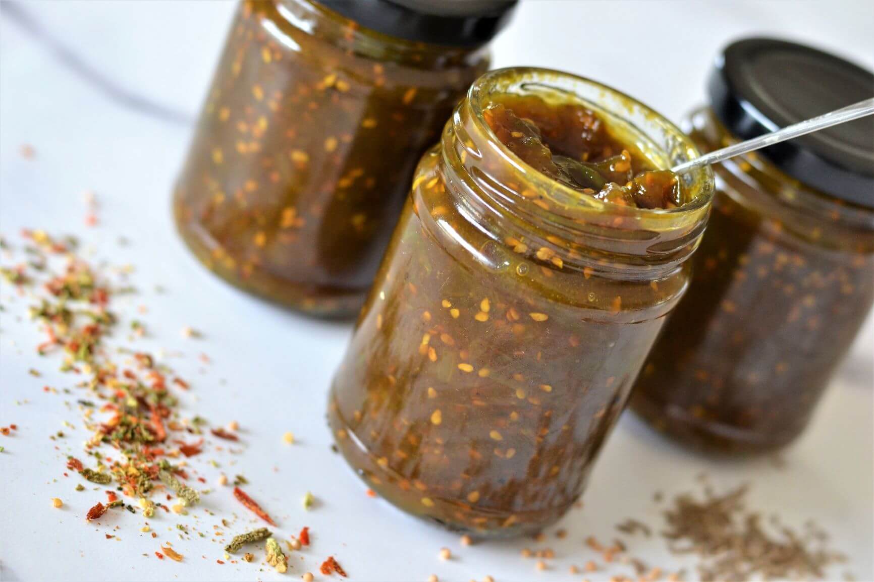 green tomato chutney in glass jars