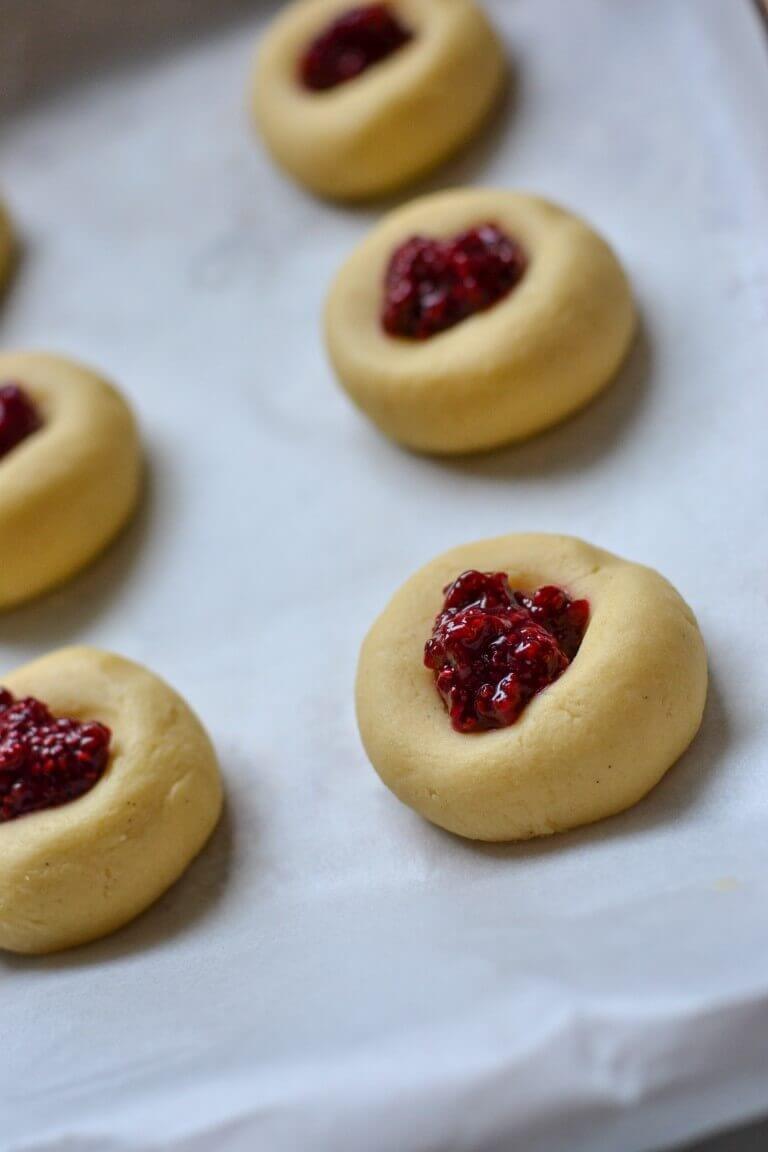 biscuit dough pressed onto a baking tray with jam in the middle