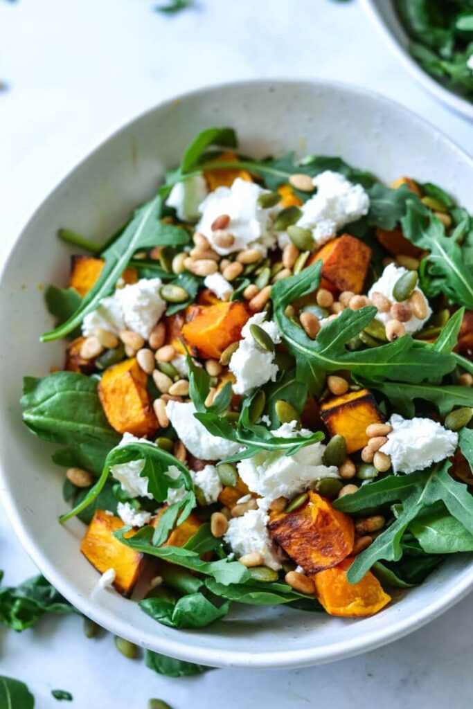A bowl of salad with pumpkin and goats cheese