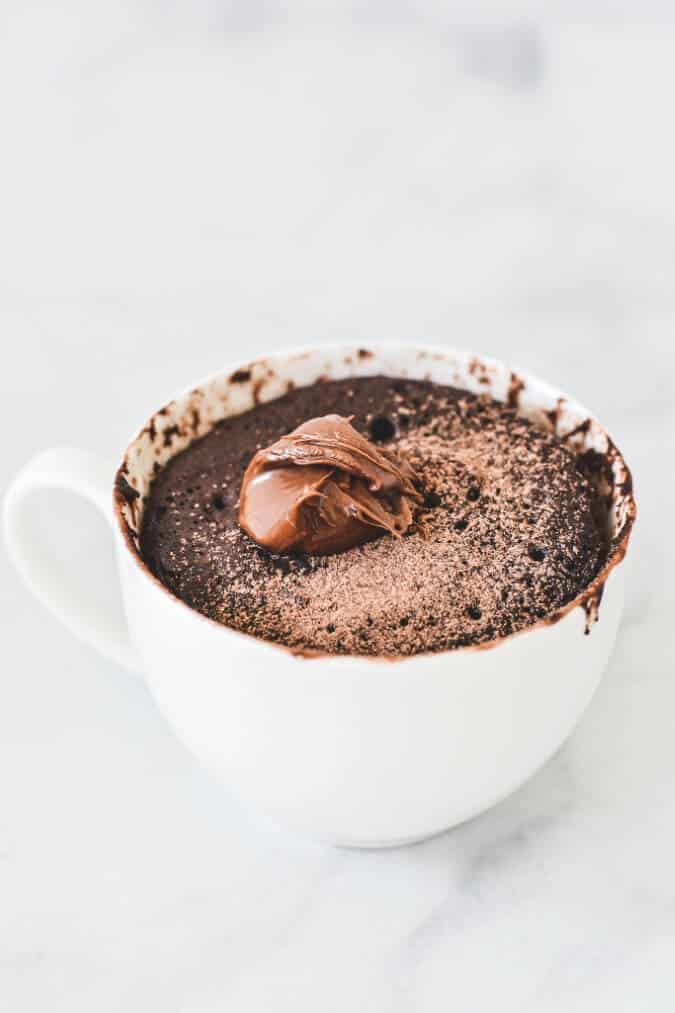 white-mug-with-chocolate-cake-and-dollop-of-nutella