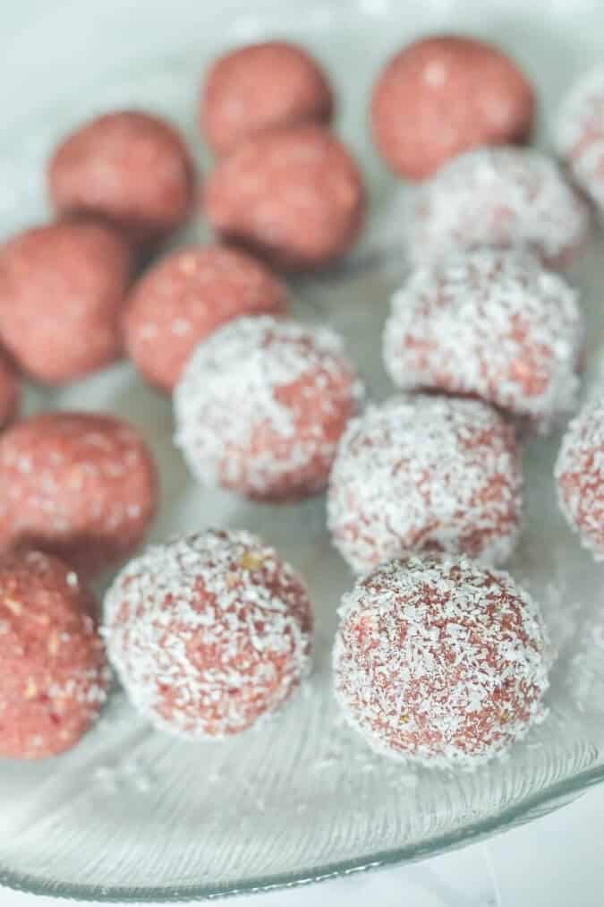 strawberry-bliss-balls-in-coconut-on-glass-plate