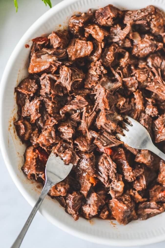 beef-cheeks-being-shredded-with-forks