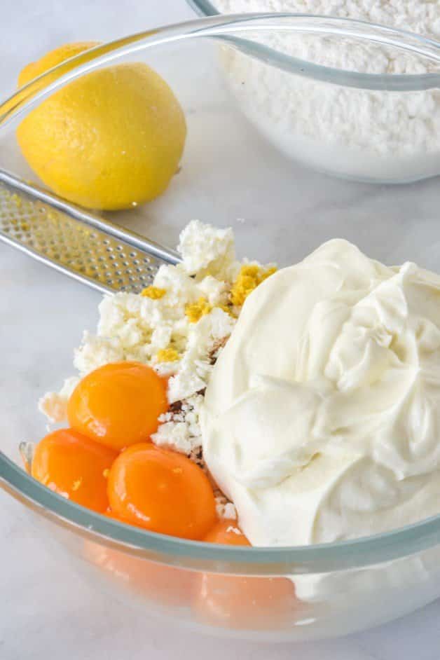 ricotta, eggs and feta in a glass bowl with lemon zest