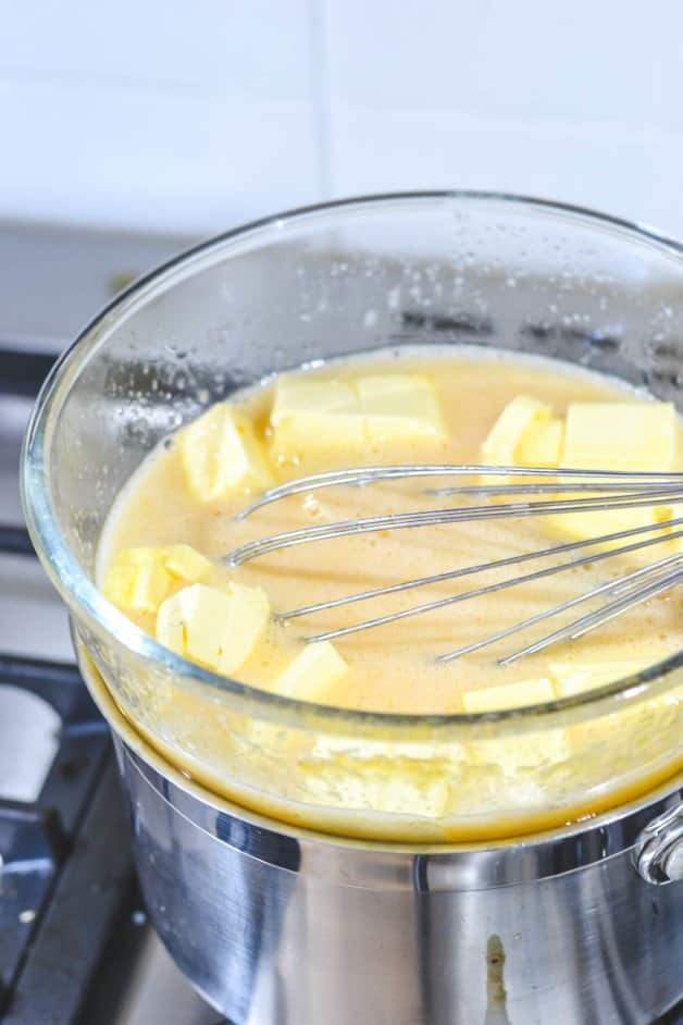 cubes-of-butter-added-to-egg-mixture-over-double-boiler