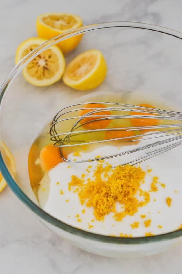 lemon-zest-and-curd-ingredients-in-glass-bowl-with-whisk