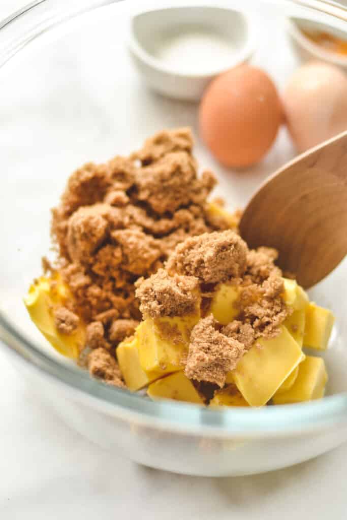 butter and sugar in a mixing bowl with a wooden spoon