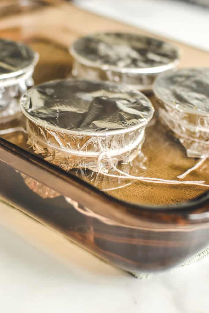 pudding moulds in a glass tray, with water