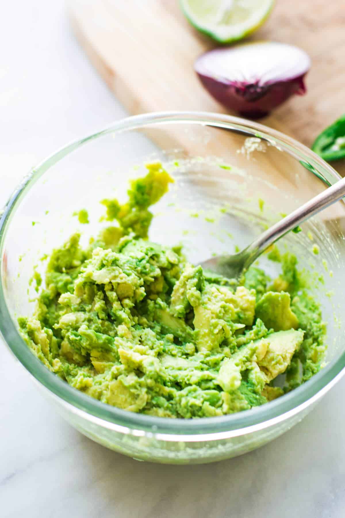 mashed avocado in a glass bowl