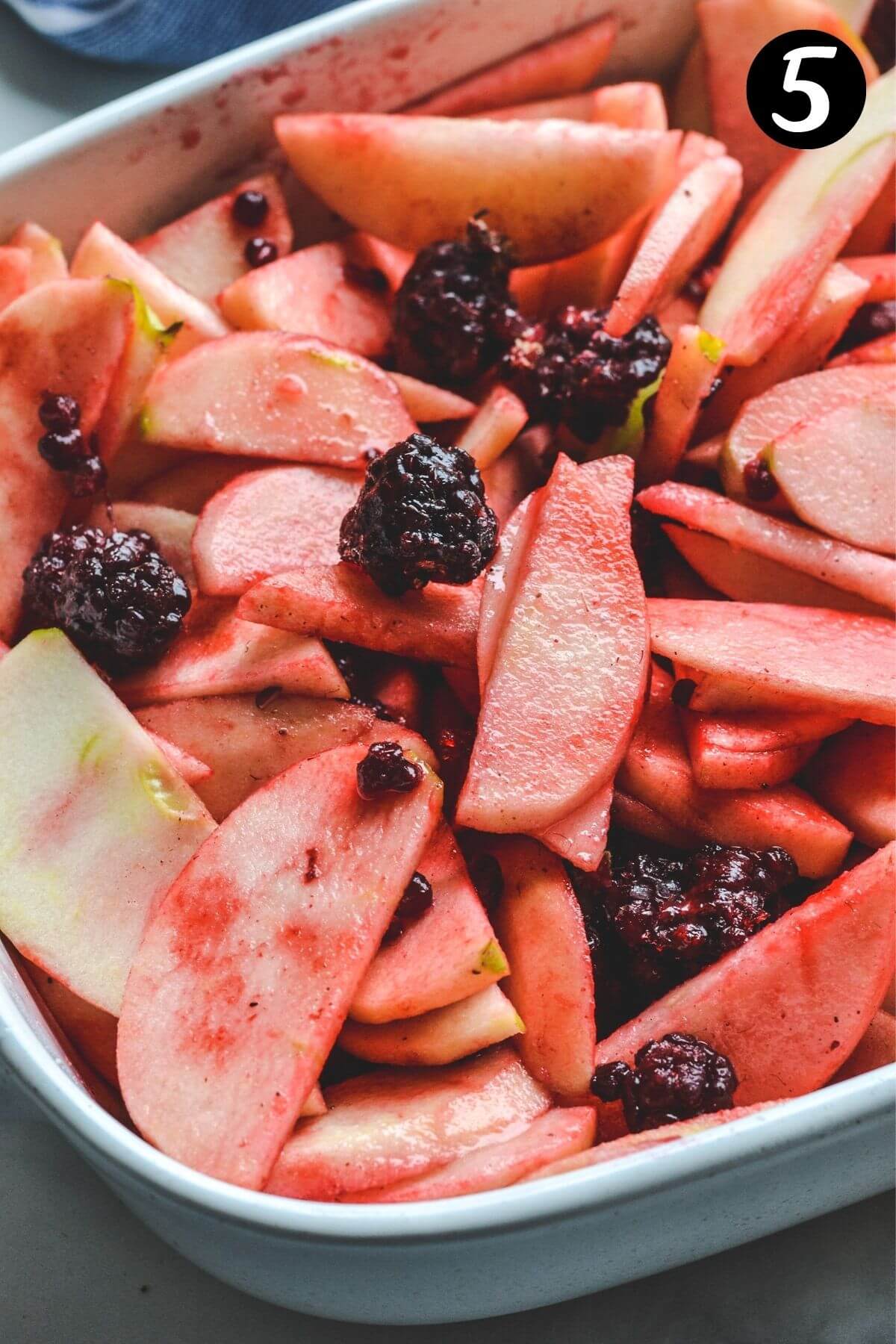 blackberries and sliced apples in a white baking dish