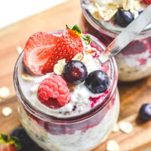 top view of finished overnight oats in glass jars with berries and a spoon