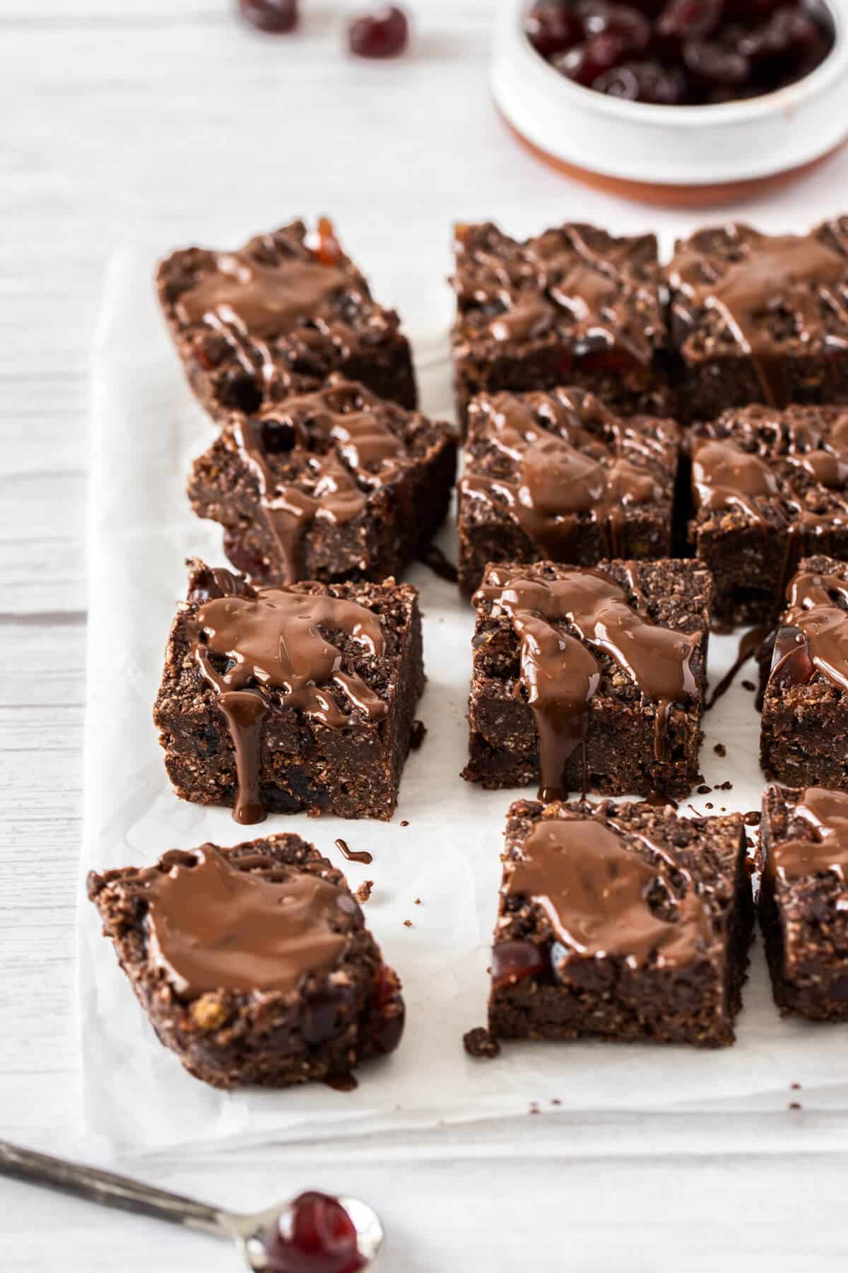 cherry ripe slice cut into pieces on a sheet of baking paper and topped with chocolate