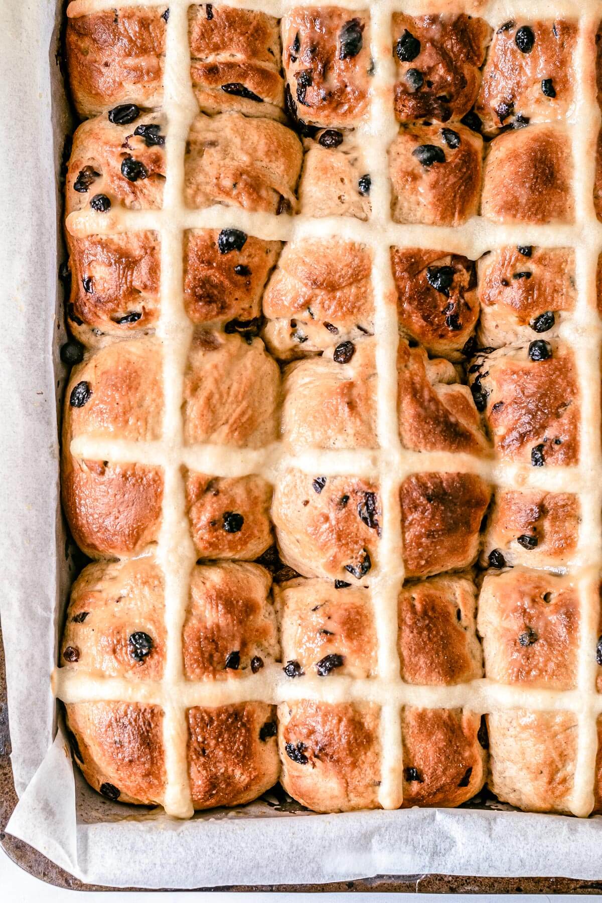 top view of finished hot cross buns in a baking tray