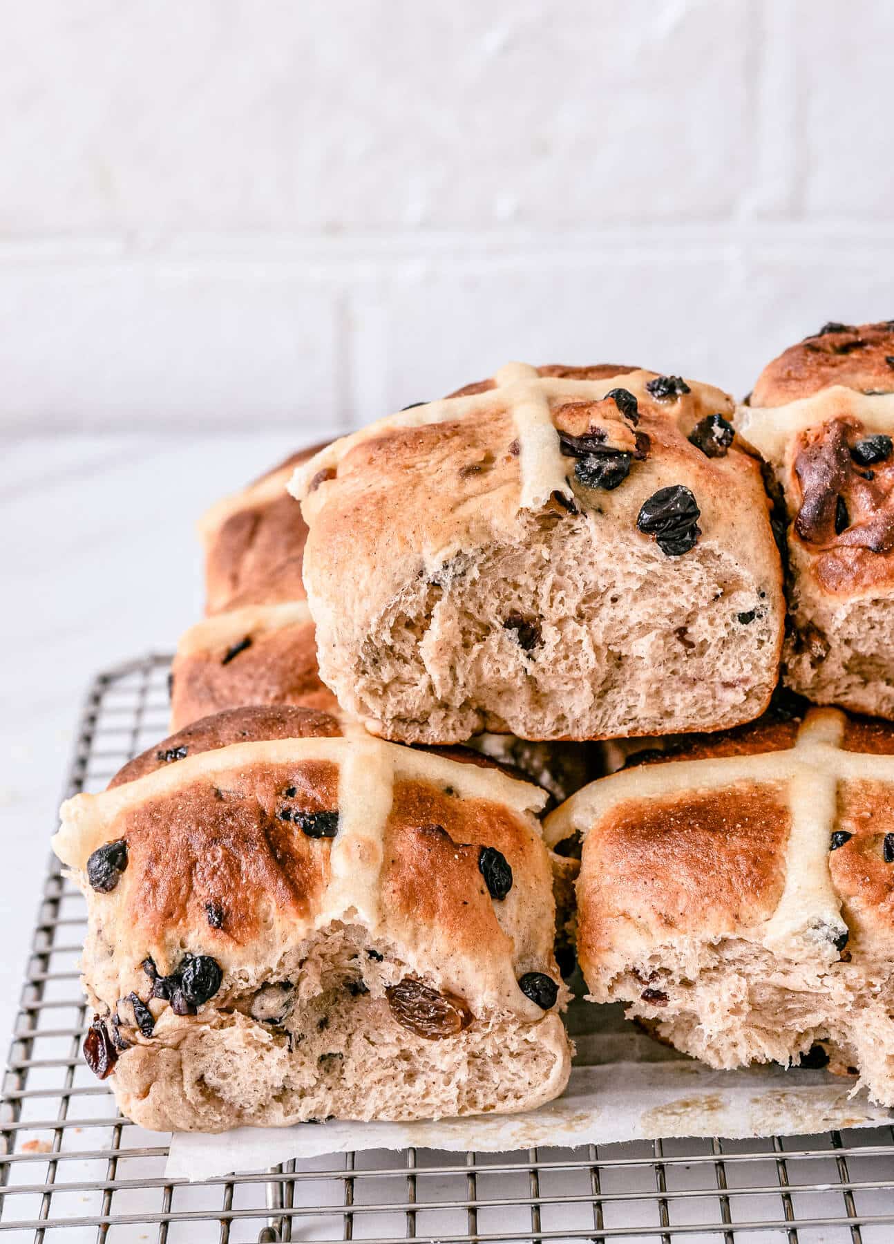 side view of finished hot cross buns cooling on a wire rack