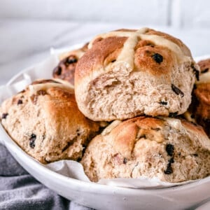 a white bowl containing hot cross buns
