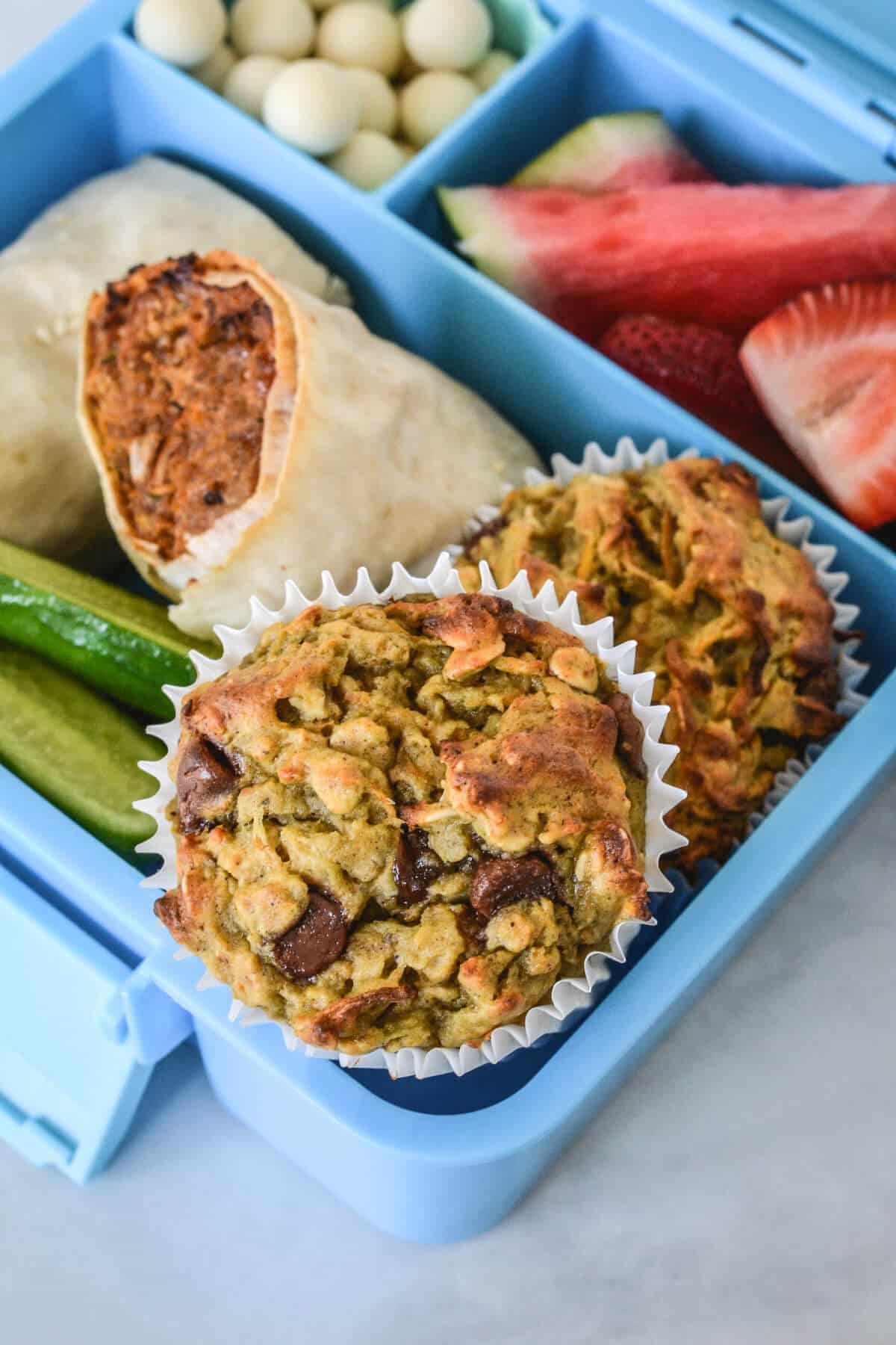 a blue lunchbox containing muffins and healthy foods