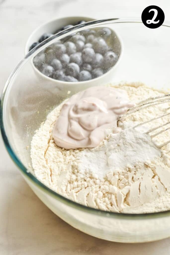 dry ingredients added to wet ingredients in a glass bowl.