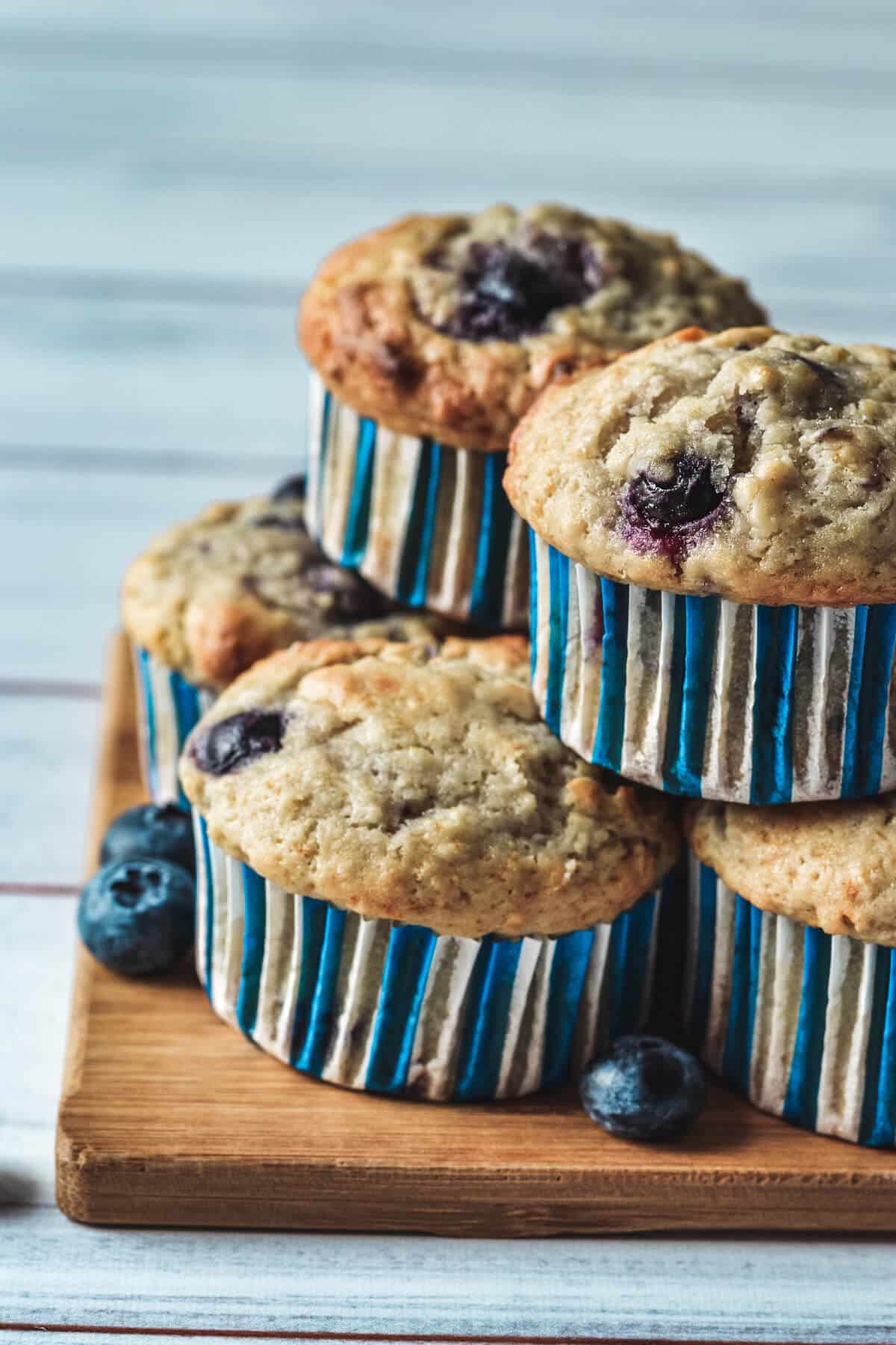 finished cupcakes piled on a wooden board.