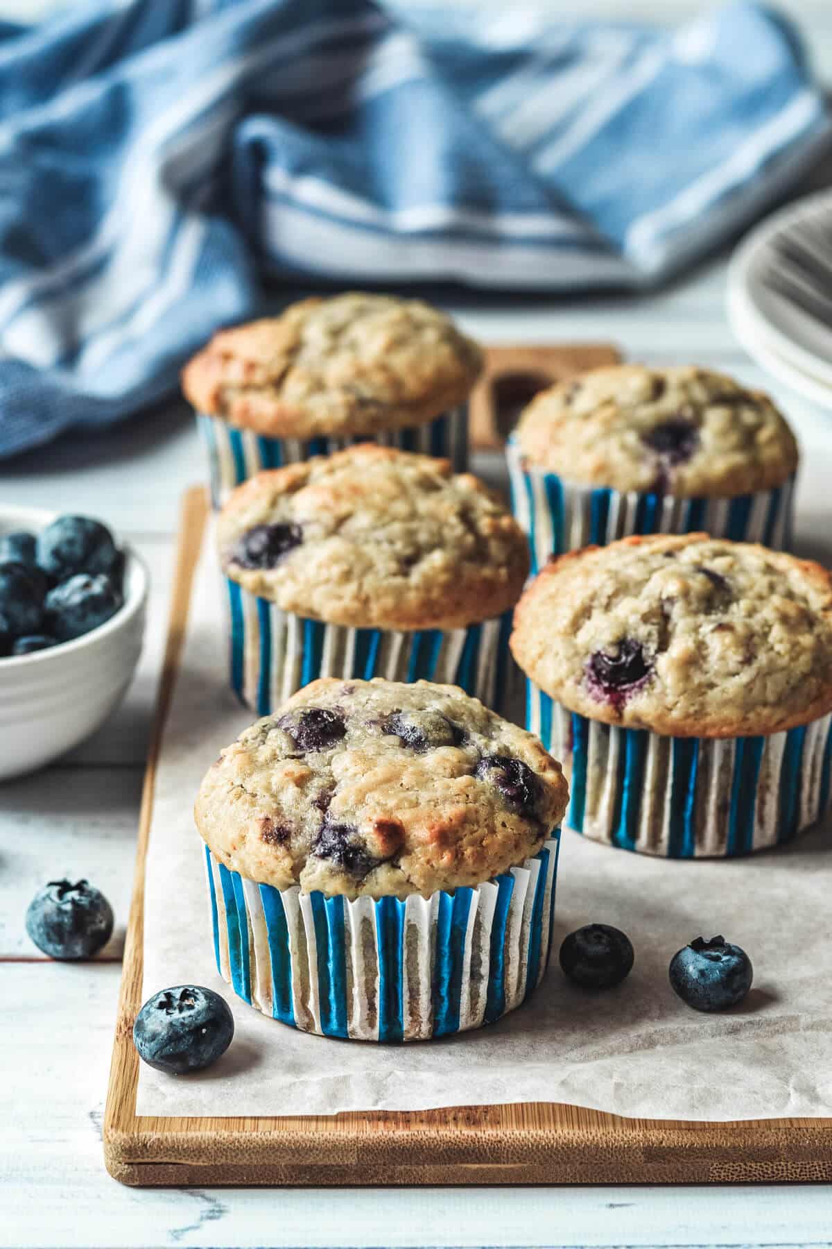 cupcakes arranged on a wooden board with blueberries