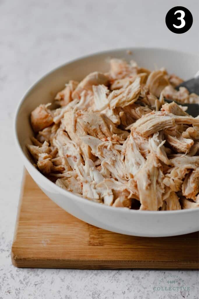 shredded chicken breast in a white bowl.