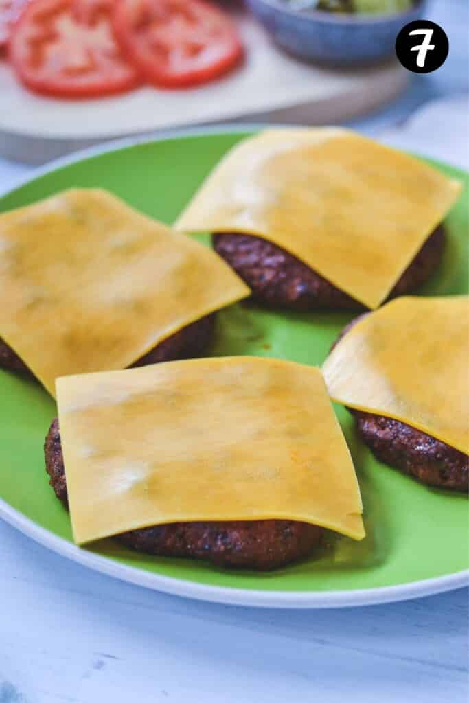 cheese melting over turkey patties on a green plate