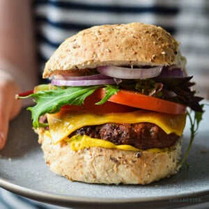 turkey burger on a grey plate, topped with salad