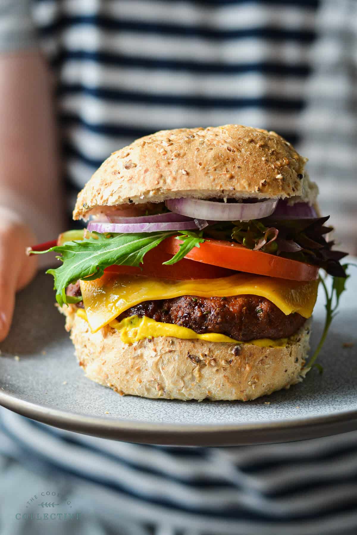 turkey burger on a grey plate, topped with salad