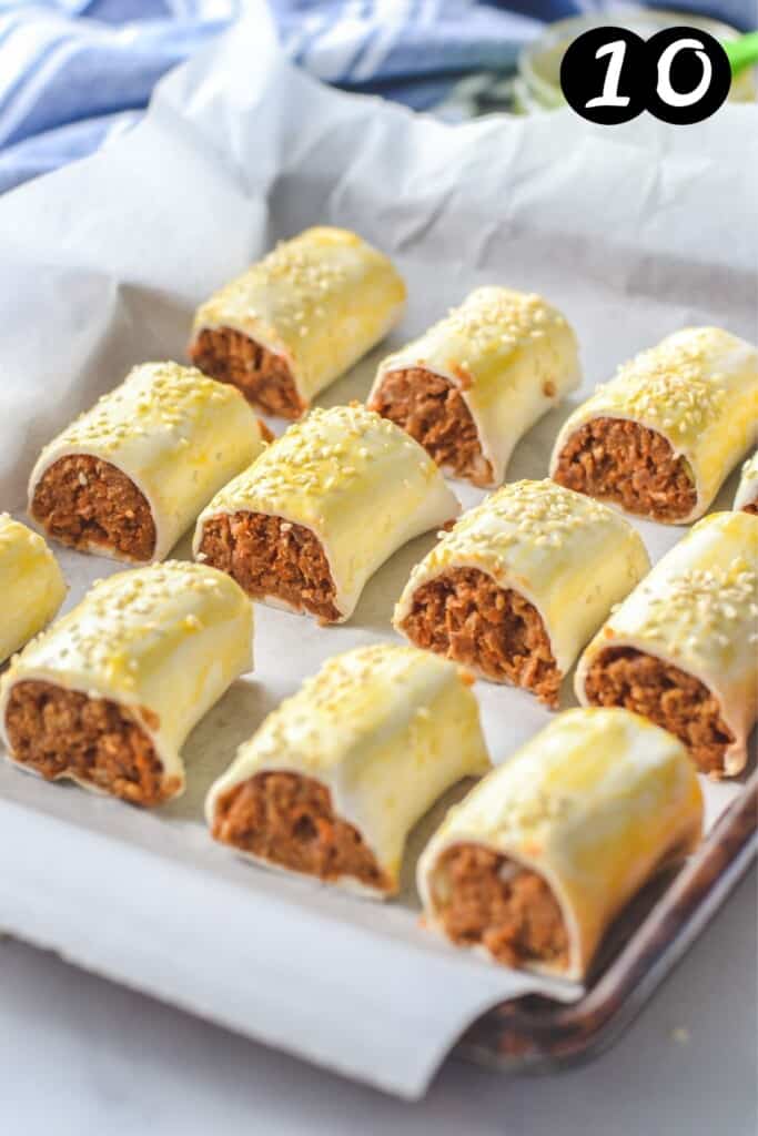 uncooked sausage rolls on a baking tray lined with paper