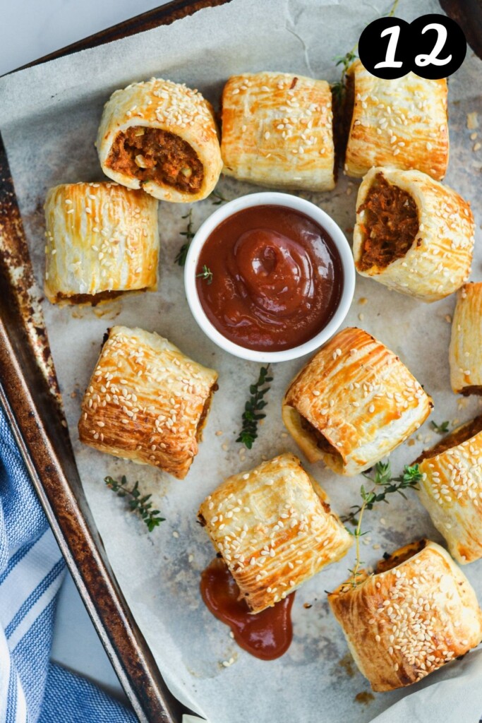 sausage rolls on a tray with tomato sauce