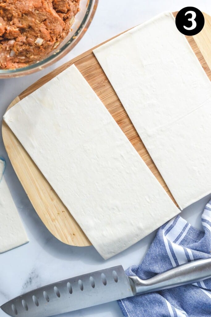 rectangles of puff pastry laid out on a wooden board