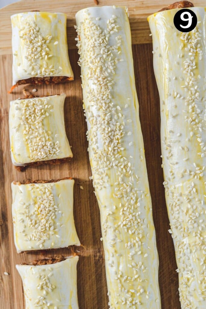 a long sausage roll being sliced into smaller pieces