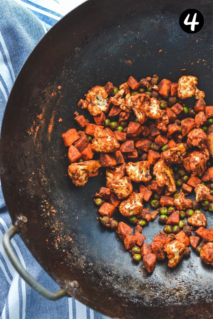 vegetables in tikka masala paste in a wok