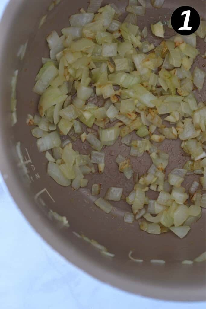 browned onions and garlic in a slow cooker pot