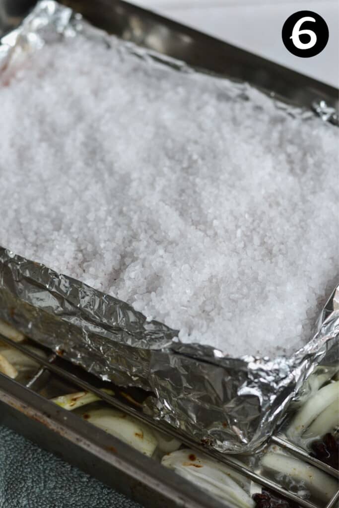 pork belly skin covered with rock salt on an oven tray