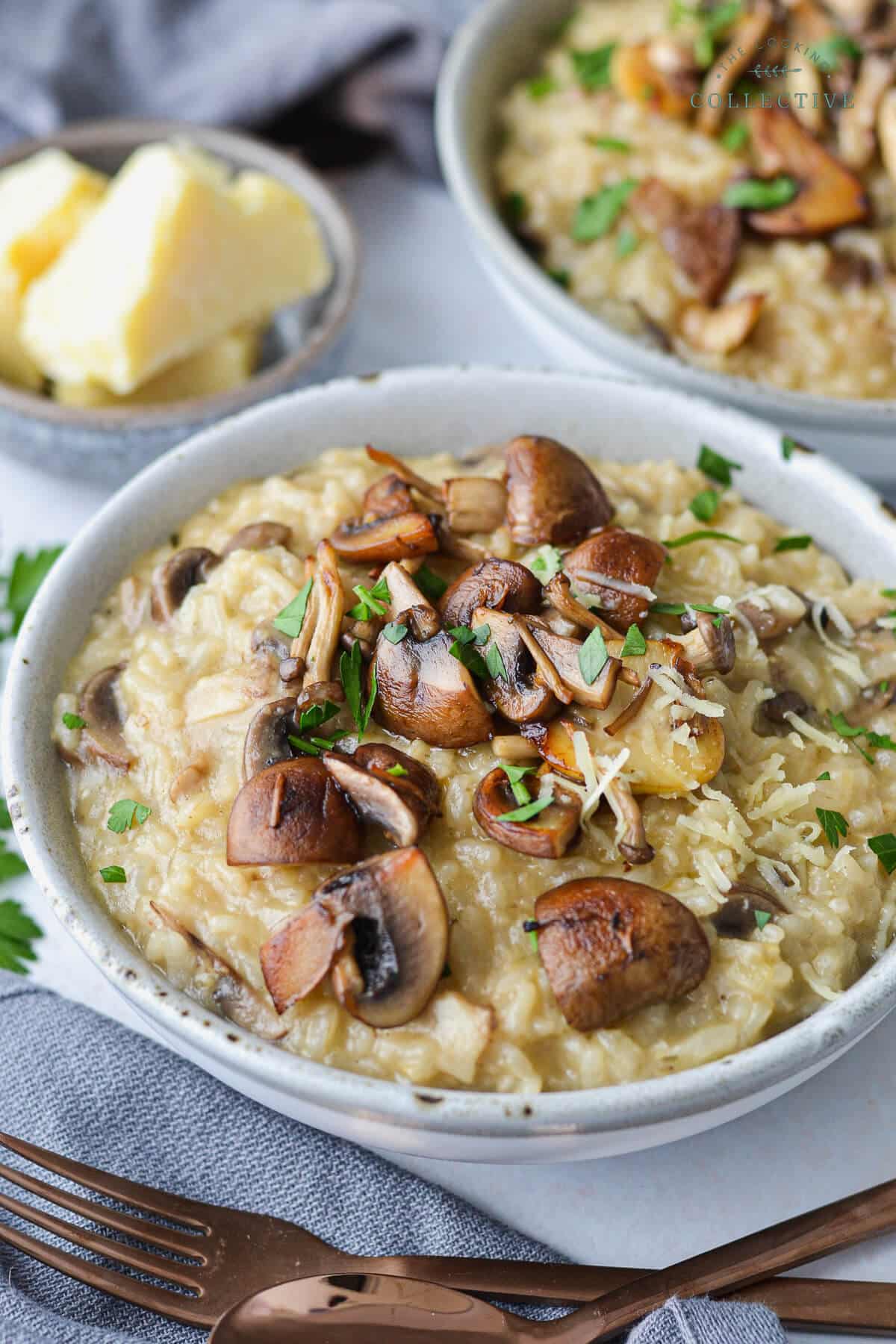 finished risotto in grey bowls topped with mushrooms and cheese