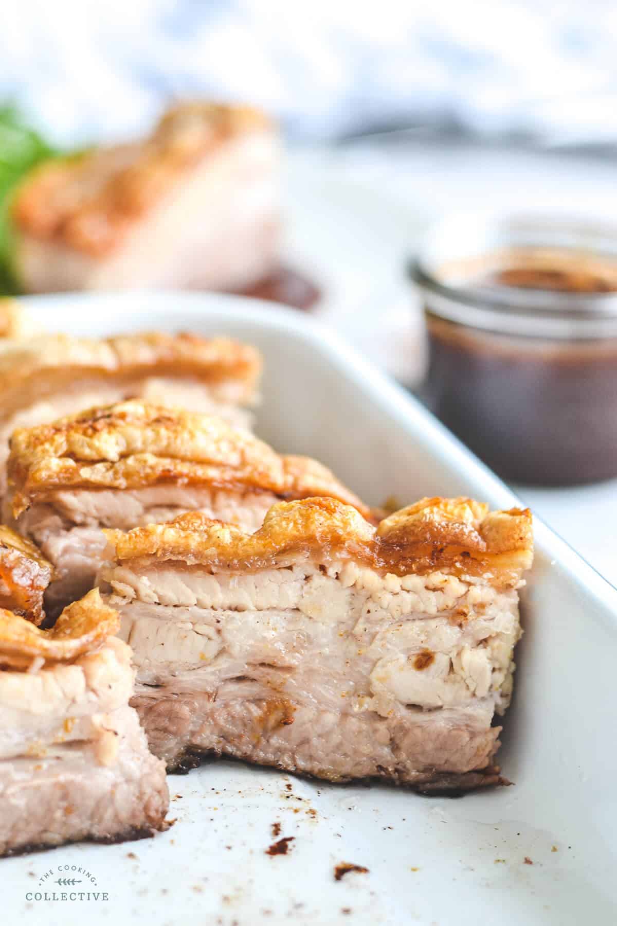 sliced pork belly with crispy crackling in a white tray