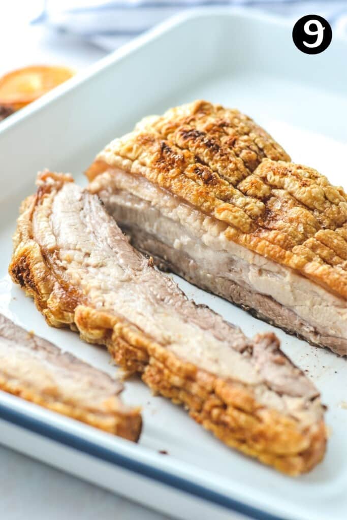 slices of pork belly with crispy crackling on a white tray