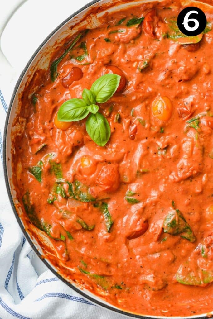 finished tomato cream cheese sauce in a pan topped with basil leaves
