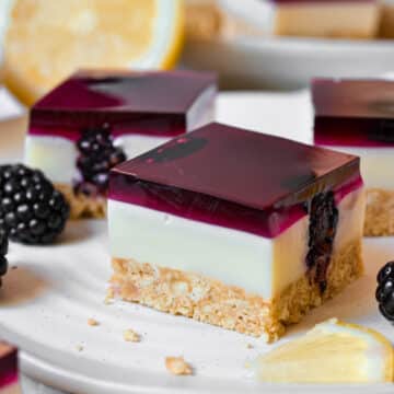 finished jelly slice on a plate with blackberries