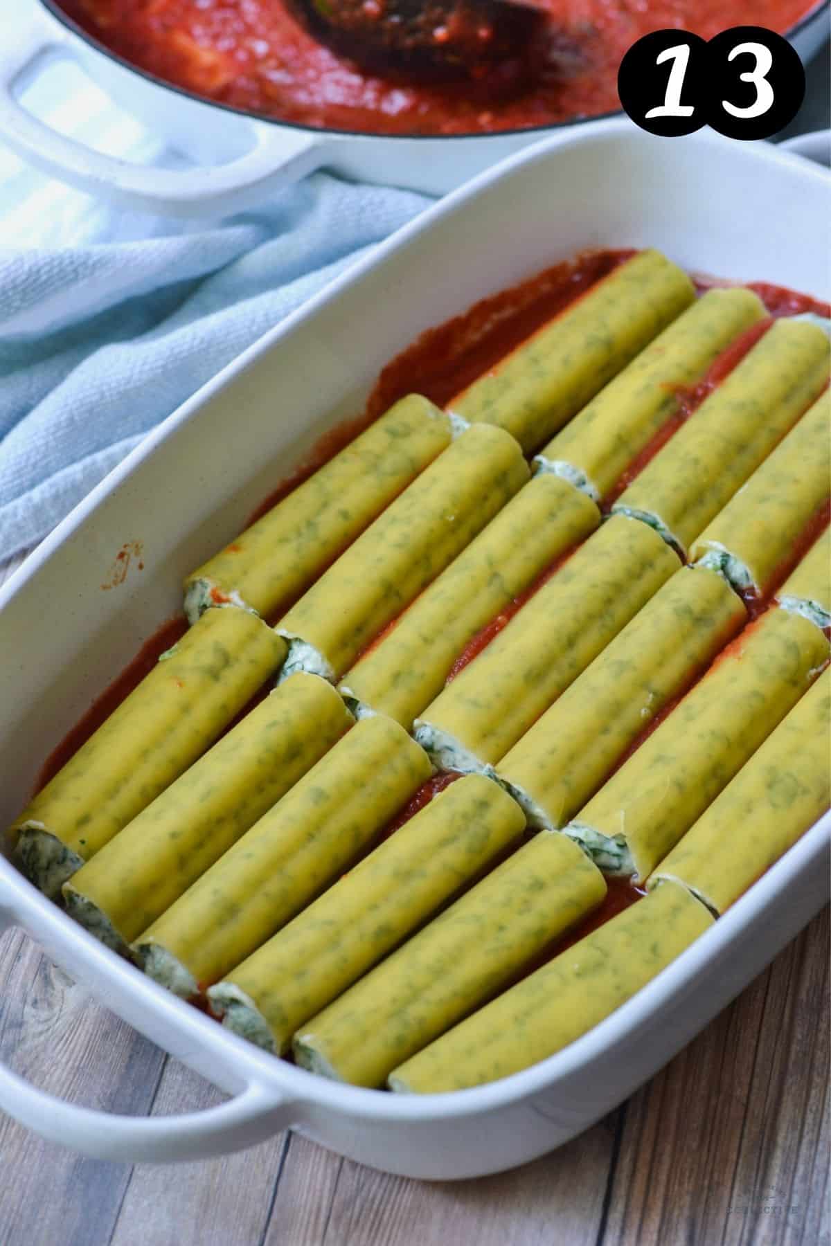 cannelloni tubes arranged over tomato sauce in a baking dish