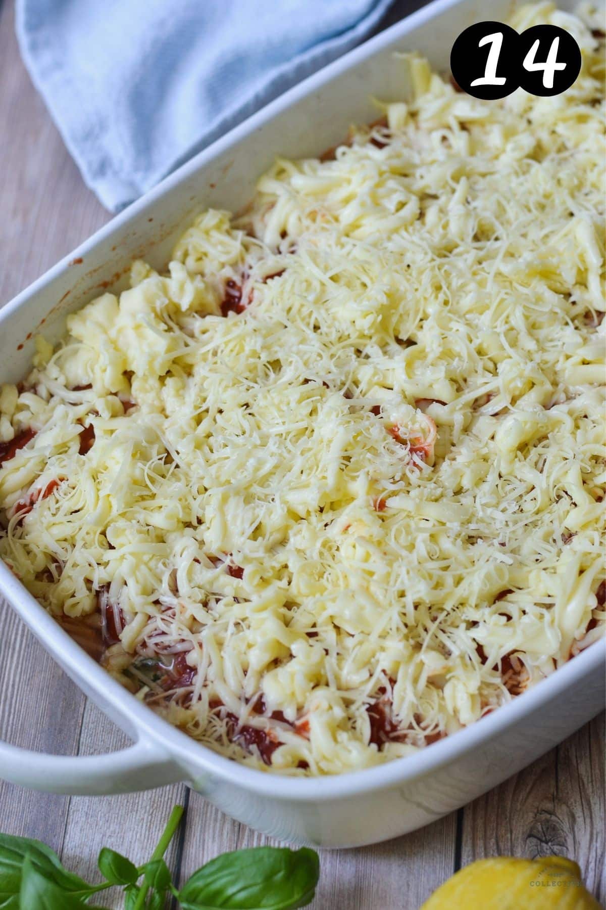 cannelloni topped with shredded cheese in a baking dish