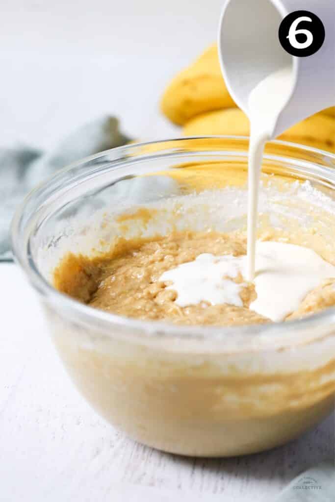 buttermilk being poured into banana cake mixture in a bowl