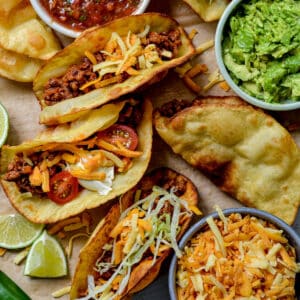 top view of finished beef tacos topped with salad and lime