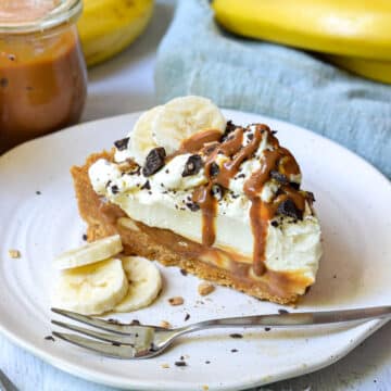 a piece of banoffee pie on a white plate with sliced bananas