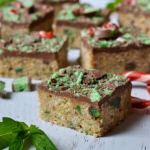 peppermint slice on a wooden table with candy canes and fresh mint leaves