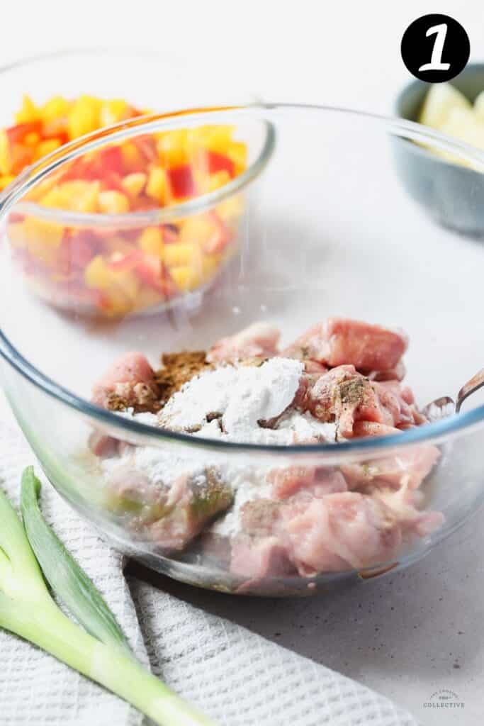 pork pieces in a glass bowl with cornflour and marinade ingredients